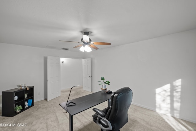 office area featuring a ceiling fan, light colored carpet, visible vents, and baseboards