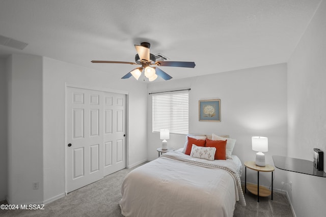 carpeted bedroom featuring a ceiling fan, a closet, visible vents, and baseboards