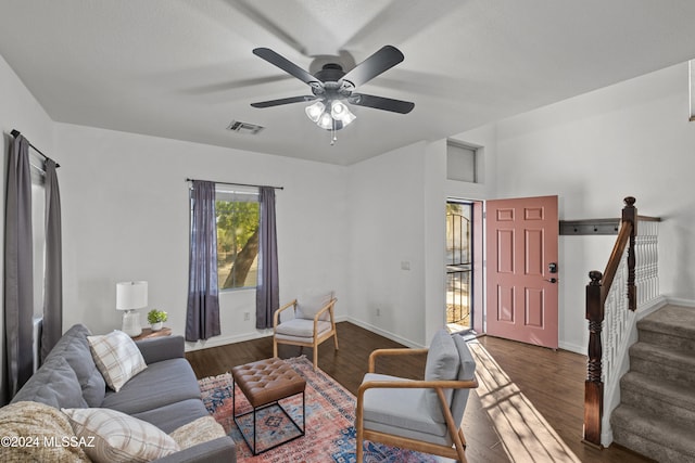 living room with baseboards, stairs, visible vents, and dark wood finished floors