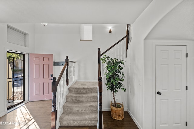 foyer entrance featuring stairs, baseboards, and wood finished floors