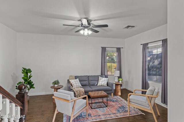 living room featuring baseboards, wood finished floors, visible vents, and a ceiling fan