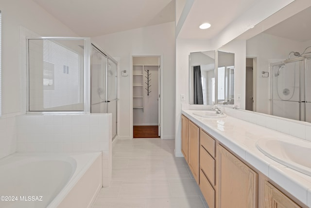 bathroom featuring vanity, separate shower and tub, and vaulted ceiling