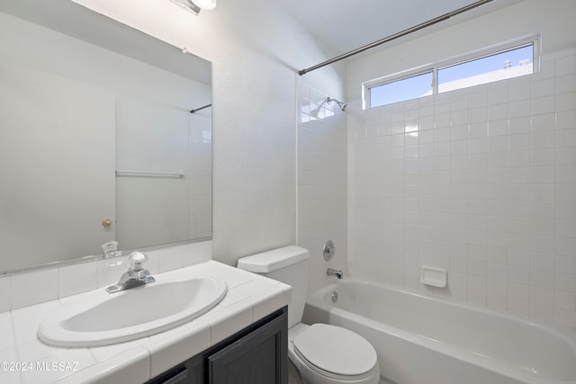 full bathroom featuring toilet, tiled shower / bath combo, and vanity