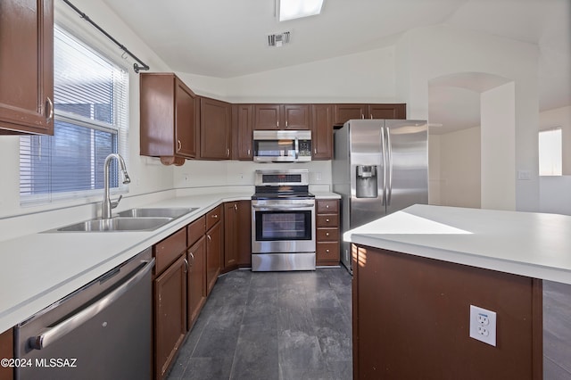 kitchen featuring appliances with stainless steel finishes, lofted ceiling, sink, and dark hardwood / wood-style flooring