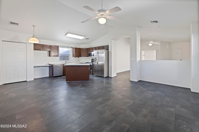 kitchen featuring sink, appliances with stainless steel finishes, hanging light fixtures, lofted ceiling, and a center island