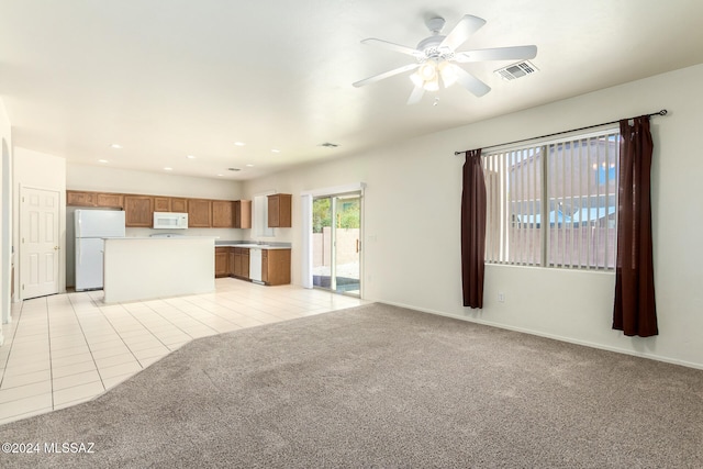 unfurnished living room featuring ceiling fan and light colored carpet