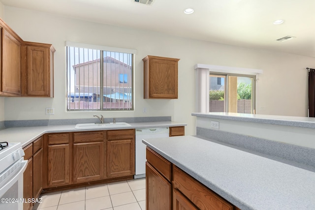 kitchen with light tile patterned floors, white appliances, and sink