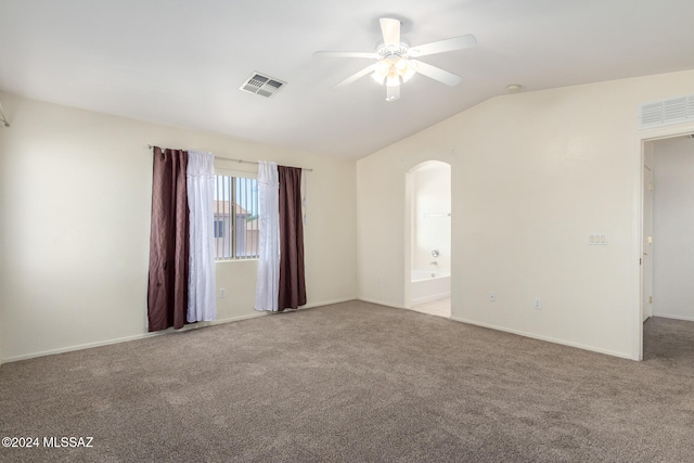 spare room featuring light colored carpet, lofted ceiling, and ceiling fan