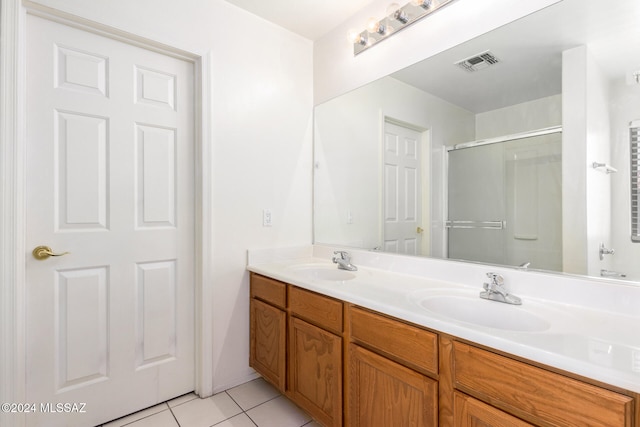 bathroom with vanity, a shower with door, and tile patterned floors