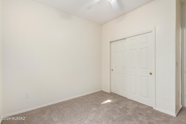 unfurnished bedroom featuring a closet, light carpet, and ceiling fan