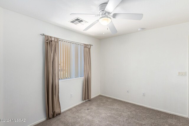 carpeted spare room with ceiling fan