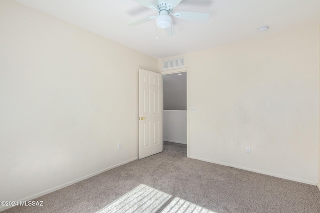 spare room with ceiling fan and light carpet