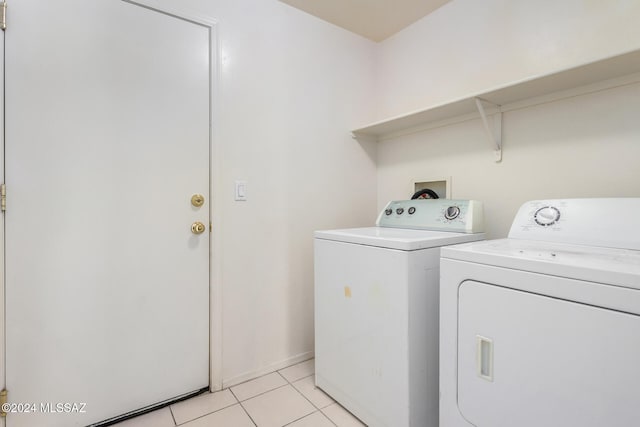 laundry area featuring light tile patterned floors and washer and clothes dryer