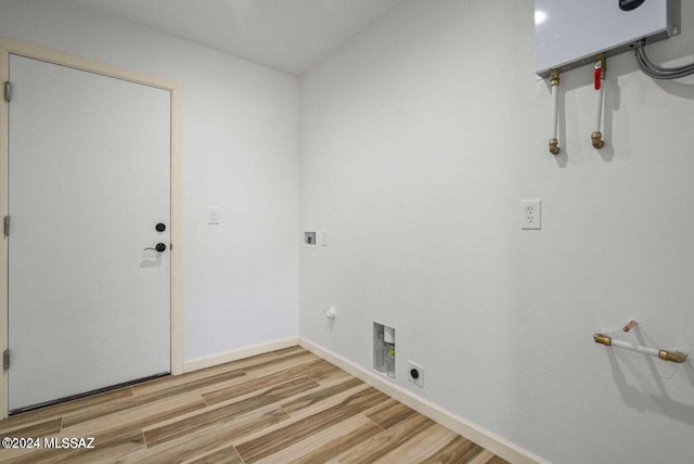 laundry area featuring hardwood / wood-style flooring, water heater, electric dryer hookup, hookup for a washing machine, and hookup for a gas dryer