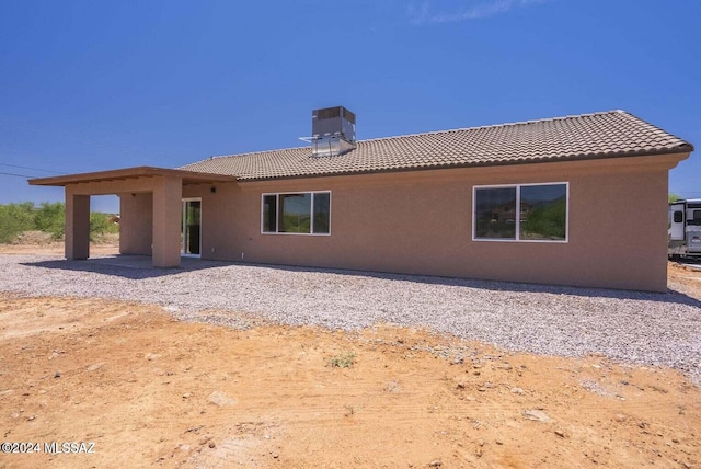 rear view of property with central AC unit and a patio area