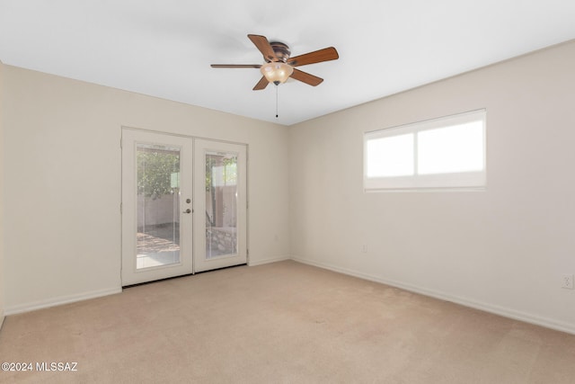 spare room with ceiling fan, light carpet, and french doors