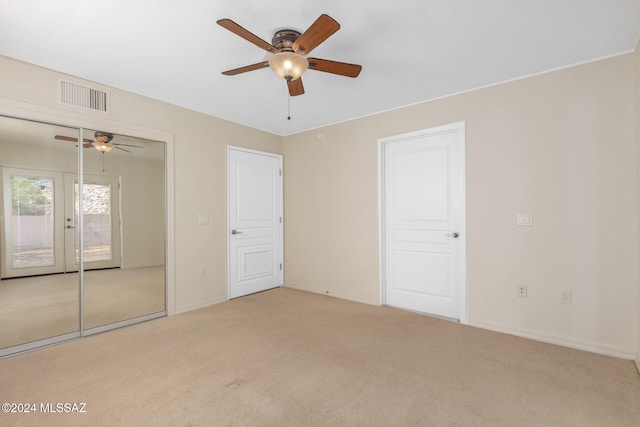 unfurnished bedroom with light carpet and ceiling fan