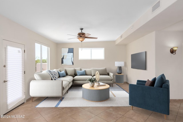 living room with light tile patterned flooring, ceiling fan, and a healthy amount of sunlight