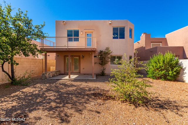 back of property featuring a patio area, french doors, and a balcony