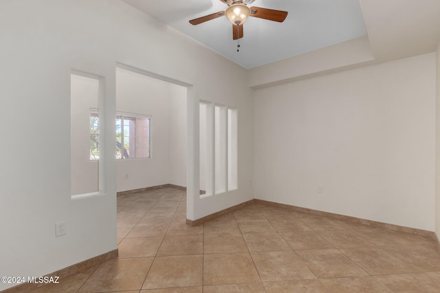 spare room with ceiling fan and light tile patterned floors