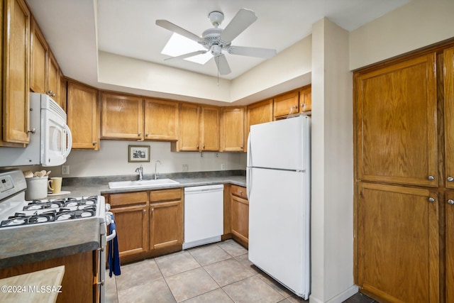 kitchen with sink, ceiling fan, a skylight, light tile patterned flooring, and white appliances