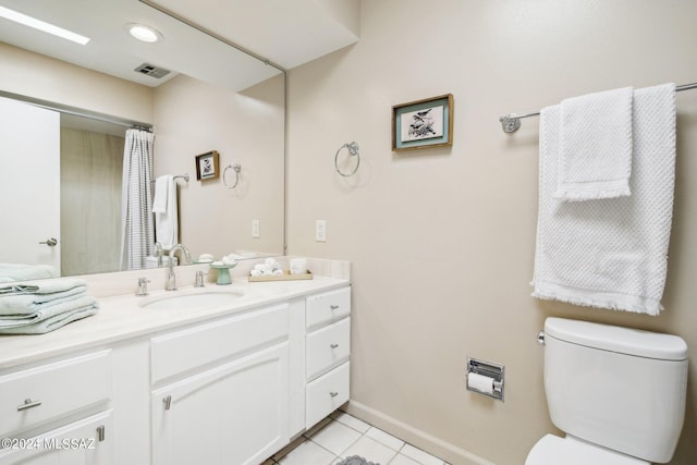 bathroom featuring toilet, vanity, and tile patterned flooring