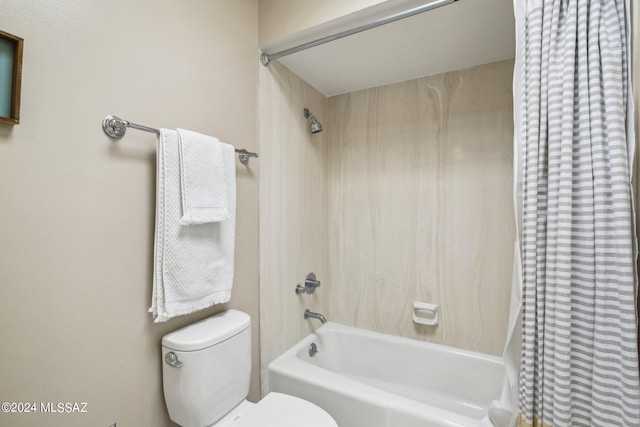 bathroom featuring tiled shower / bath combo and toilet