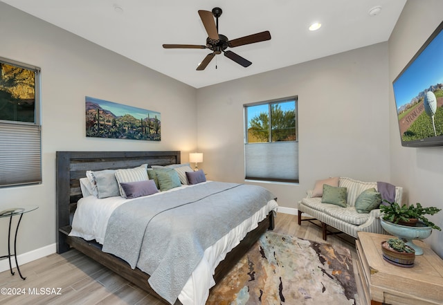 bedroom with light hardwood / wood-style flooring and ceiling fan