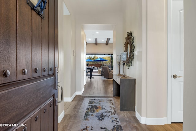 foyer entrance with beamed ceiling and light hardwood / wood-style flooring