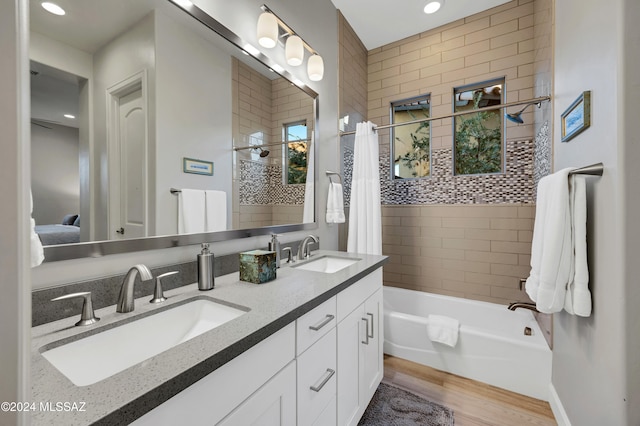 bathroom with hardwood / wood-style flooring, vanity, and shower / bath combination with curtain