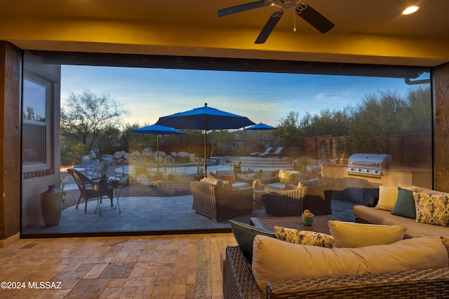 patio terrace at dusk with a grill, area for grilling, an outdoor living space, and ceiling fan