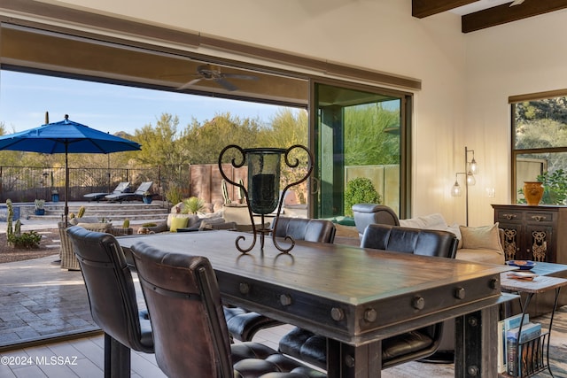 dining area with beamed ceiling, ceiling fan, and light wood-type flooring