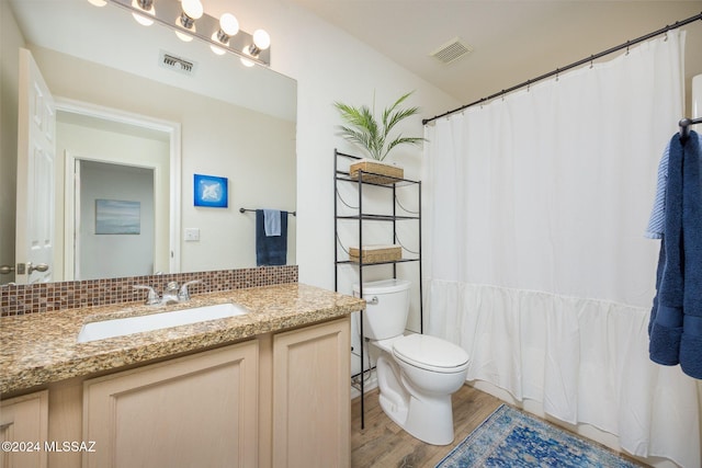 bathroom featuring wood-type flooring, toilet, and vanity