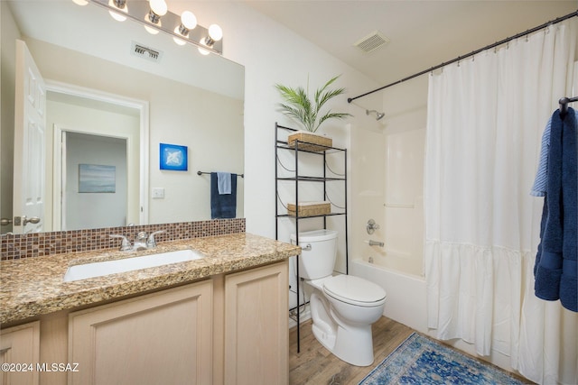 full bathroom featuring wood-type flooring, vanity, shower / bathtub combination with curtain, and toilet