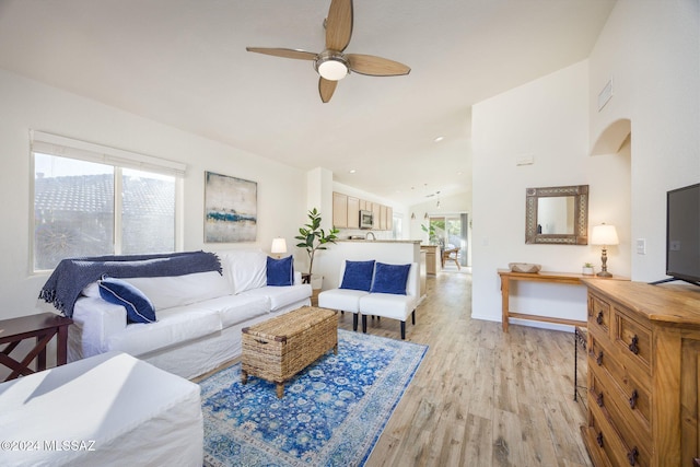 living room with high vaulted ceiling, light hardwood / wood-style flooring, a healthy amount of sunlight, and ceiling fan