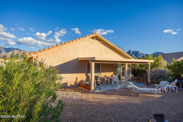 rear view of house featuring a mountain view and a patio area