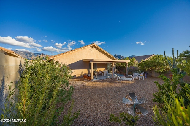 back of house featuring a mountain view and a patio