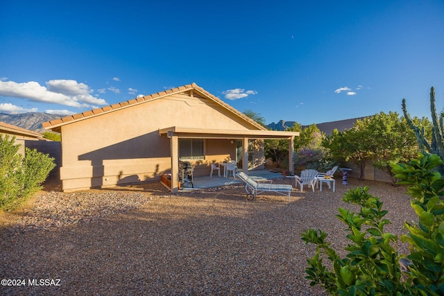 rear view of house featuring a mountain view and a patio