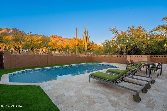 view of swimming pool with a mountain view and a patio area