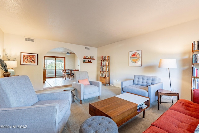 living room with light colored carpet, arched walkways, and visible vents