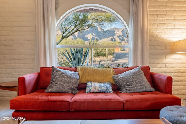 living room with brick wall and a healthy amount of sunlight