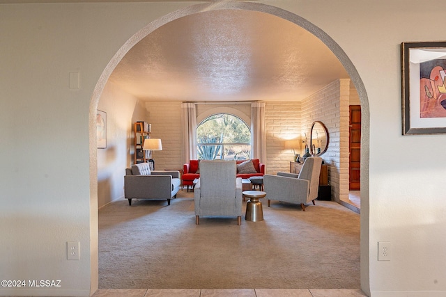 living area featuring light carpet, arched walkways, a textured ceiling, and log walls