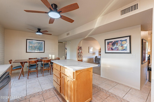 kitchen with visible vents, arched walkways, dishwasher, light countertops, and light tile patterned flooring