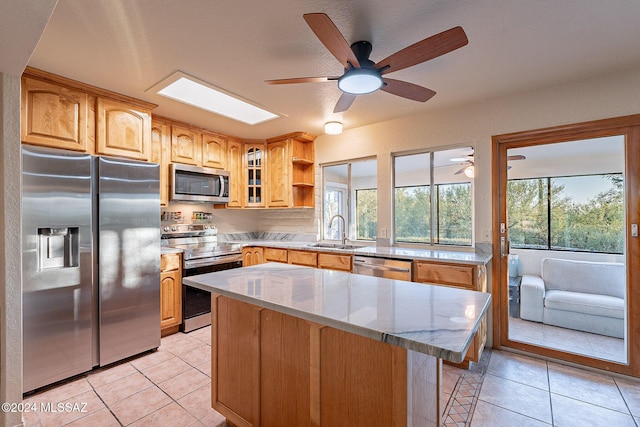 kitchen with a skylight, a kitchen island, glass insert cabinets, stainless steel appliances, and open shelves