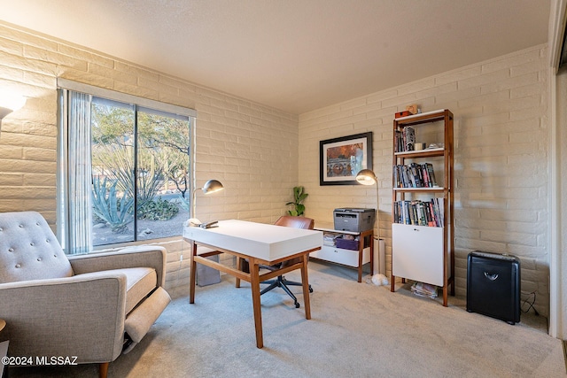 office area featuring brick wall and light colored carpet