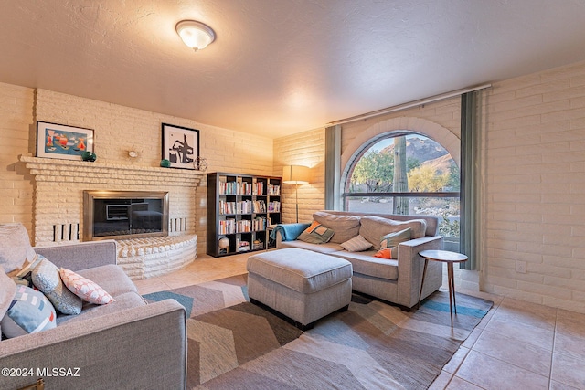 living area featuring a textured ceiling, a fireplace, and tile patterned floors