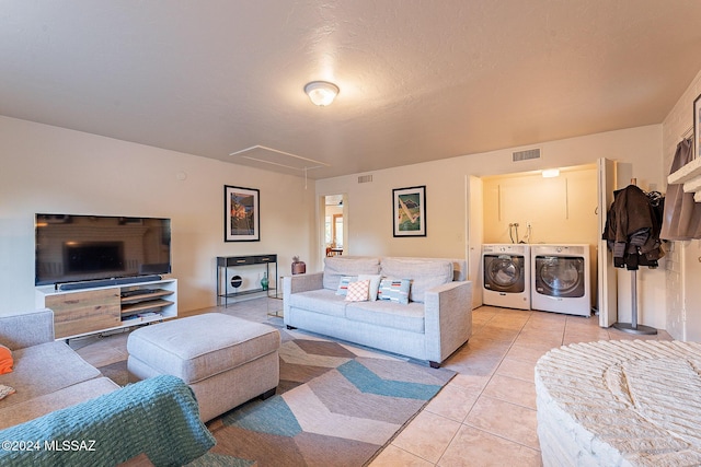 living room with light tile patterned floors, separate washer and dryer, visible vents, and attic access