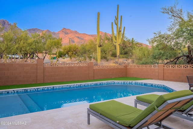 view of pool with a patio, a fenced backyard, a mountain view, and a fenced in pool