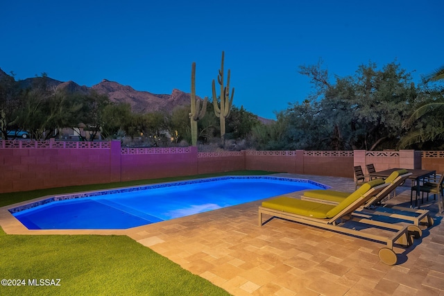 view of pool featuring a patio area, a fenced backyard, a mountain view, and a fenced in pool