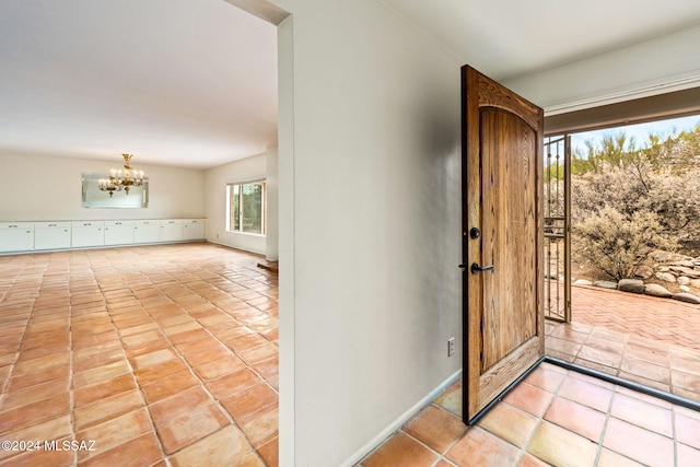 entryway featuring a notable chandelier and light tile patterned flooring